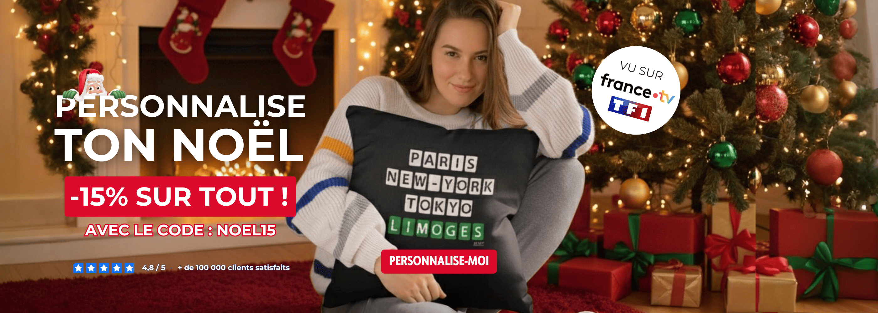 Jeune femme souriante tenant un coussin noir personnalisé avec les villes Paris New York Tokyo Limoges devant un sapin de Noël. Idée de cadeau accessoire personnalisé à sa ville de coeur