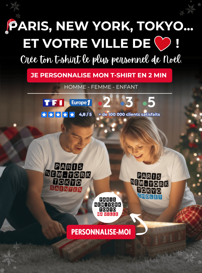 Couple souriant découvrant un cadeau de Noël ; ils portent des t-shirts blancs personnalisés avec les noms des villes 'Paris New York Tokyo' et 'Ta Ville', pour un t-shirt personnalisé pour Noël sur le thème de la ville de cœur.