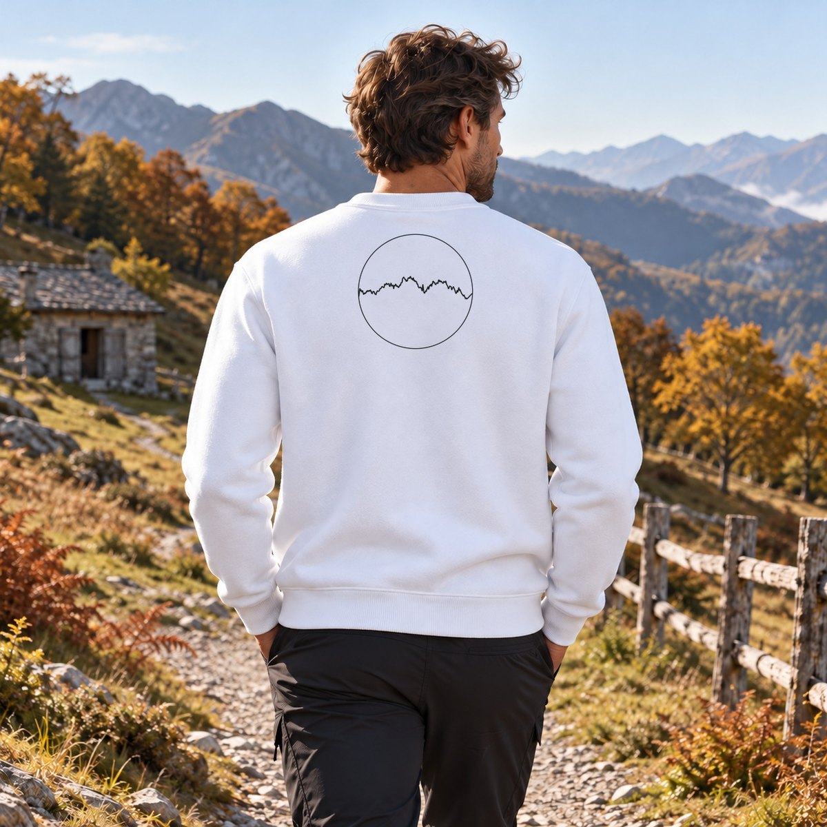 Sweat blanc Les Pyrénées porté de dos dans la rue d'un village de montagne